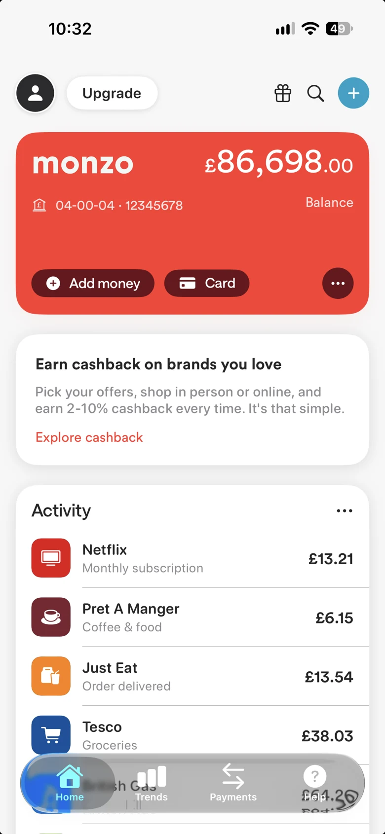 Monzo entertainment-build preview 1: A coral-red Monzo-style card shows a staged pound balance and reference account details.